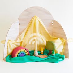 a wooden toy set with a tent and toys