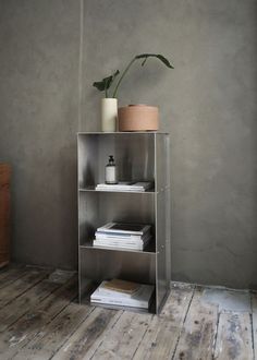 a metal shelf with some books and a potted plant sitting on top of it