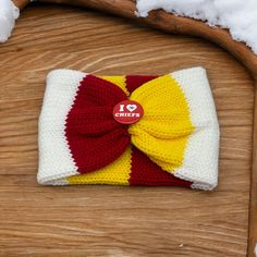 a crocheted bow tie on top of a wooden chair with snow around it