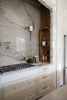 a stove top oven sitting inside of a kitchen next to a wall mounted book shelf