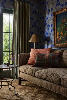 a living room scene with focus on the couch and pillows in front of the window