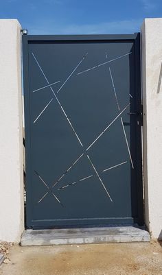 an open gate on the side of a building with no people in it and blue sky above