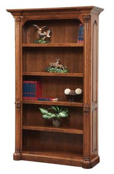 a wooden bookcase with three shelves filled with books and figurines on top