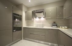 a modern kitchen with stainless steel appliances and white counter tops