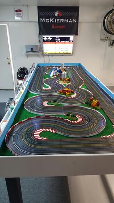 a toy race track set on display in a room with a sign above it that says mckernan raceway