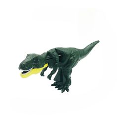 a toy dinosaur with a yellow ball in it's mouth on a white background