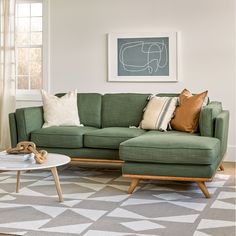 a living room with a green couch and coffee table