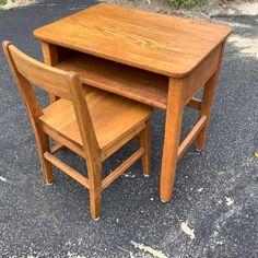 two wooden chairs sitting next to each other in front of a small table and chair