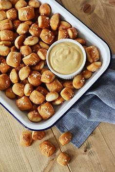 a white dish filled with pretzels and dipping sauce