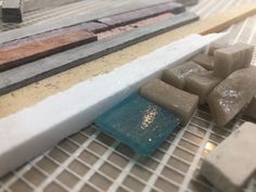 several pieces of tile sitting on top of a tiled floor next to a window sill