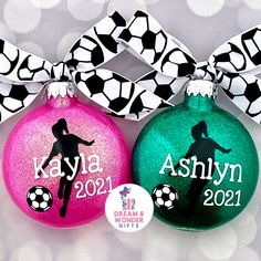 three personalized christmas ornaments with soccer balls and bows on them, one is pink, the other is green