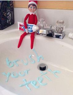 the elf is sitting in the bathroom sink with his toothbrush and toothpaste