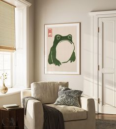 a living room with a couch, chair and framed frog print on the wall above it