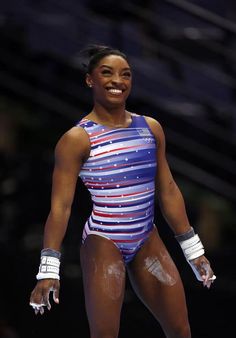 a woman standing on top of a wrestling ring wearing a blue and white striped leotard