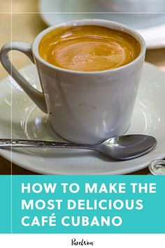 a cup of coffee sitting on top of a white plate next to a silver spoon