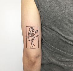 a woman with a tattoo on her arm holding a flower in front of her left arm