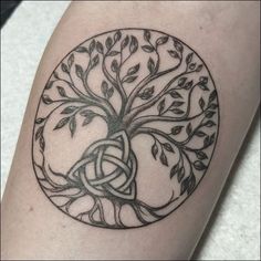 a black and white tree of life tattoo on the arm