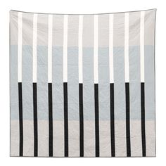 a gray and black striped quilt on a white background