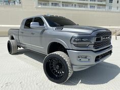 a silver truck is parked in the sand