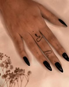 a woman's hand with black nail polish on it and the word love written in cursive writing