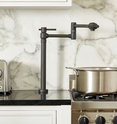 a stove top oven sitting next to a pot on top of a burnerdle