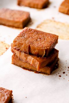 three pieces of food sitting on top of a piece of paper next to crackers