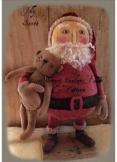 a stuffed animal with a santa clause holding a teddy bear in it's arms