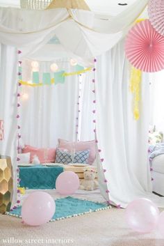 a canopy bed with pink and white balloons