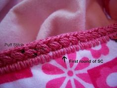 close up of pink and white fabric with black stitching on it, showing the first round of sc