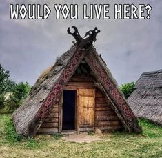 an old thatched house with two large scissors on the roof and one door open