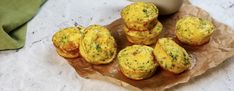 small muffins are sitting on top of a piece of wax paper next to an egg