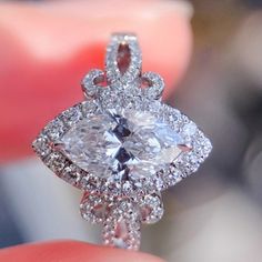 a close up of a person holding a diamond ring