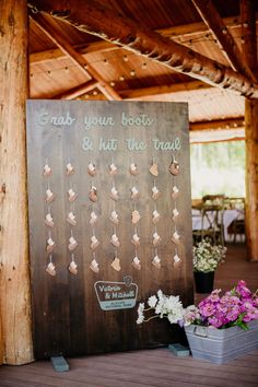 a sign that says grab your boots and hit the trail with flowers in front of it