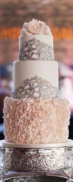 a three tiered wedding cake with white frosting