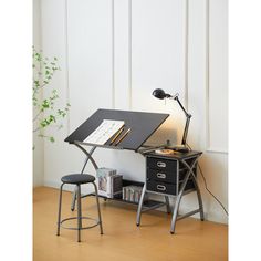 a black desk with a lamp on top and a book shelf next to it in front of a white wall