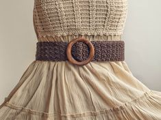 a dress that has a wooden ring on it's belt and is made out of fabric