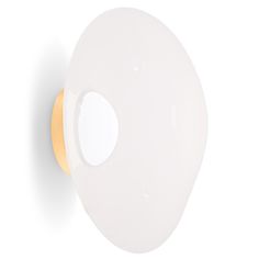 a white and gold colored light fixture on a wall with an oval hole in the middle