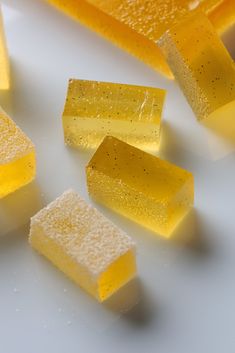 several pieces of yellow cake sitting on top of a white table