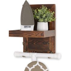 an ironing board and potted plant hanger on a wooden shelf with hooks