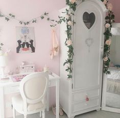 a white desk and chair in a room with flowers on the wall behind it,