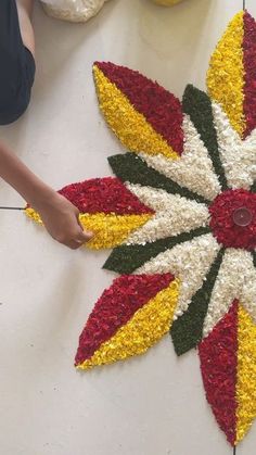 a person standing next to a flower arrangement on the ground