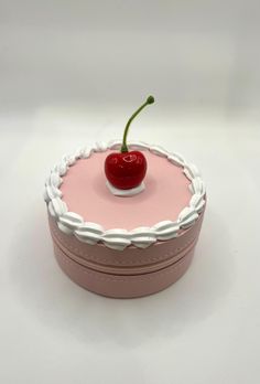 a small round cake with a cherry on top