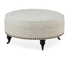 a round ottoman sitting on top of a wooden table