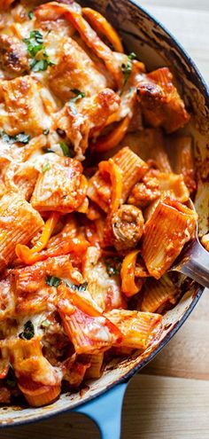 a casserole dish with chicken, cheese and tomato sauce in it on a wooden table