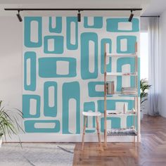 a green and white wall mural in a living room with a ladder next to it