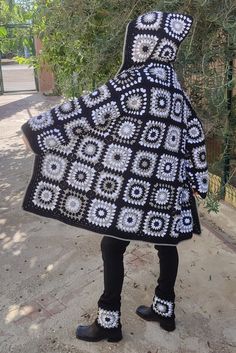 a person wearing a black and white crocheted coat