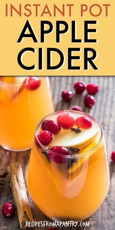 two glasses filled with apple cider on top of a wooden table