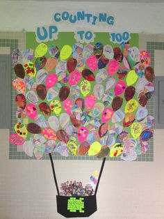 a bulletin board with lots of buttons on it and a sign that says counting up to 100