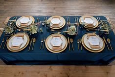 the table is set with gold and blue place settings