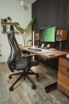 an office chair sitting in front of a desk with a computer monitor and speakers on it